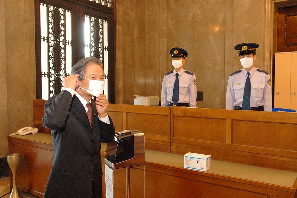 正玄関でマスクを着用する江田議長（平成21年5月18日）の写真　クリックすると拡大写真がご覧いただけます